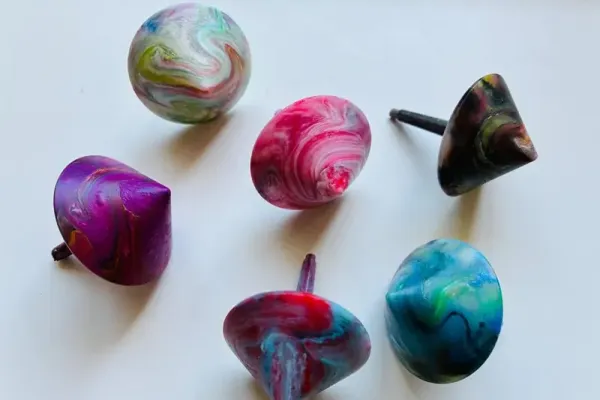 Sechs bunte, farbverlaufene Kunststoffobjekte – Ergebnisse eines Experiments im SKZ-Schülerlabor „Plastik verstehen – Zukunft gestalten“, bei dem Jugendliche den Umgang mit Polymeren und Recycling erforschen.