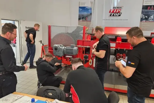 Teilnehmer einer Schulung bauen gemeinsam eine Maschine auf.