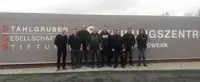 Sieben Teilnehmer der Fortbildung im Vulkaniseur-Handwerk stehen vor dem Schild des Schulungszentrums der STAHLGRUBER GESELLSCHAFTER-STIFTUNG in Warstein-Belecke.
